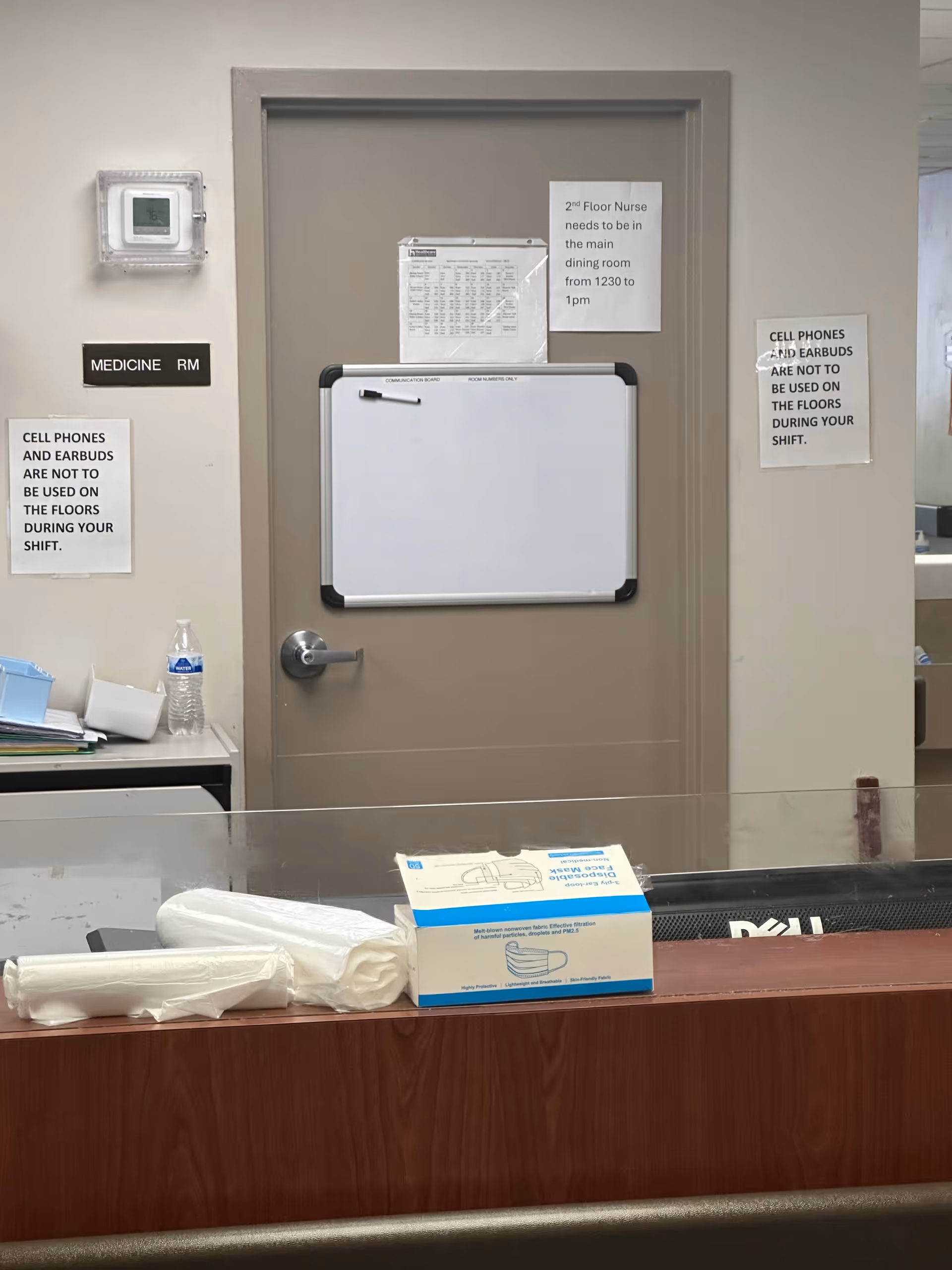 Door labeled Medicine Room with whiteboard, signs, and a counter in a nursing facility.