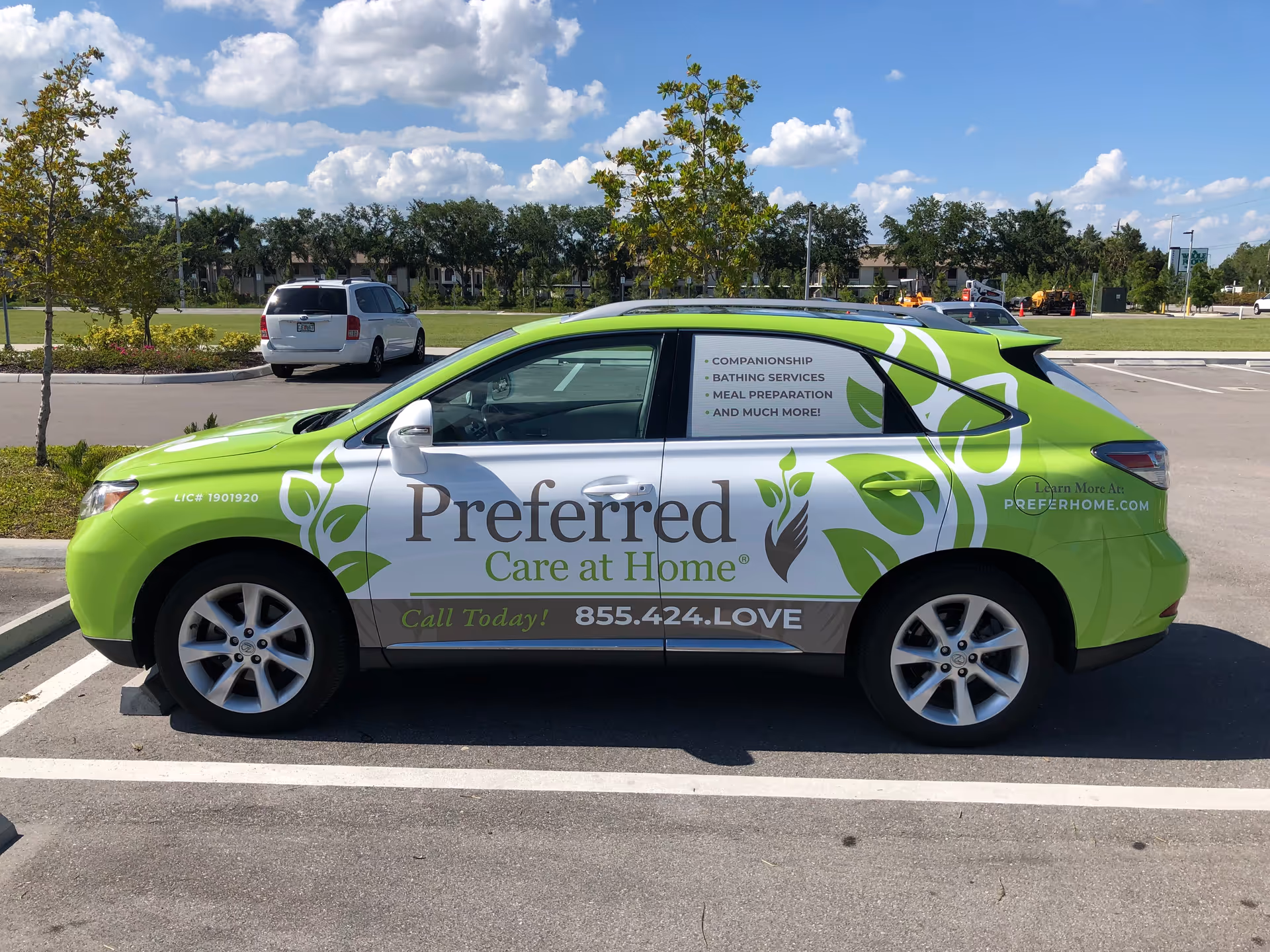 Bright green Preferred Care at Home van parked in a sunny lot with trees