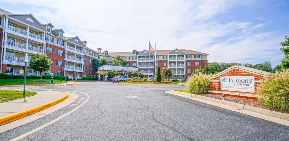 Exterior view of Harmony at Falls Run with brick building and entrance sign.