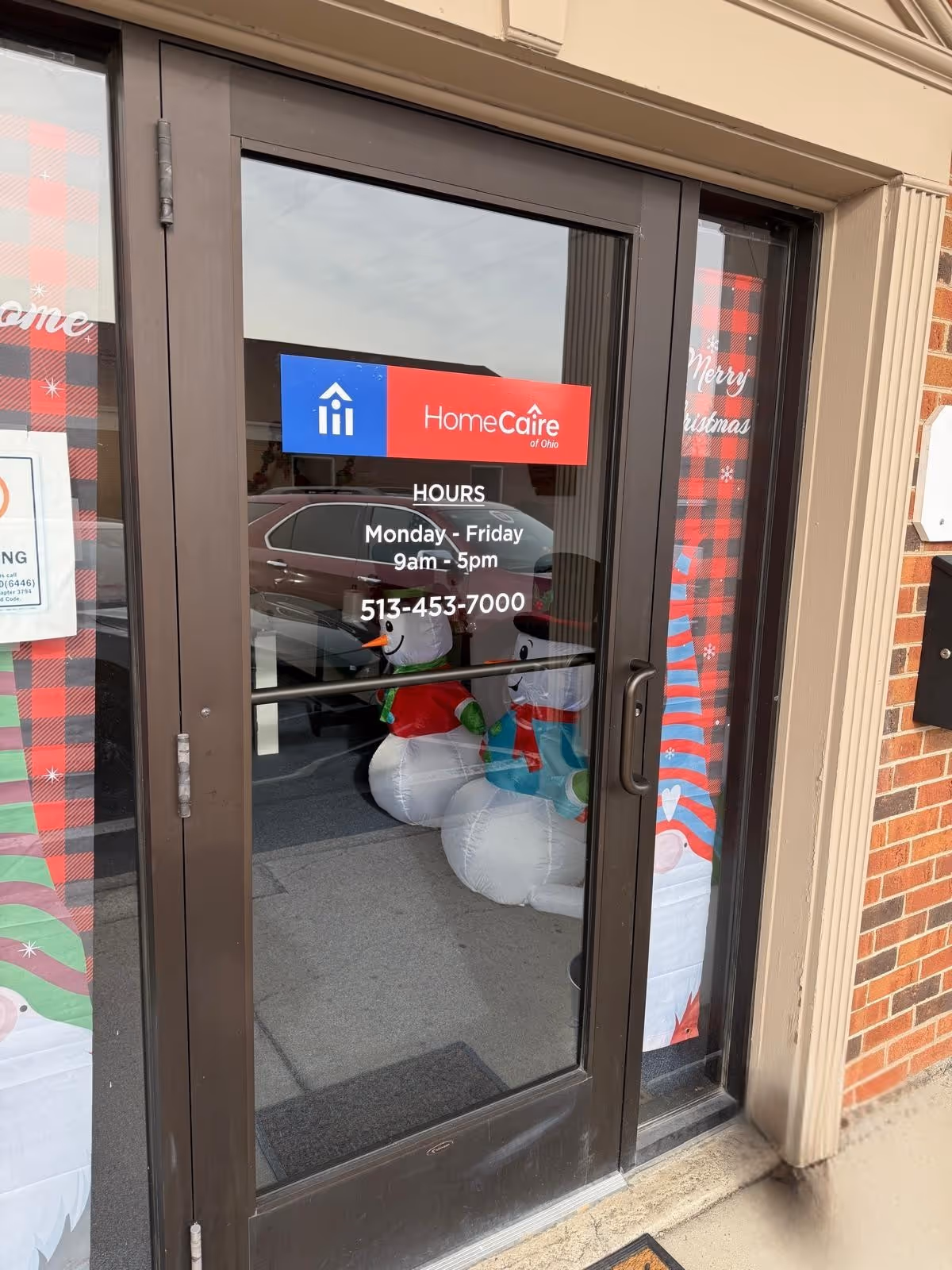 Glass front door with HomeCare of Ohio sign and holiday decorations.