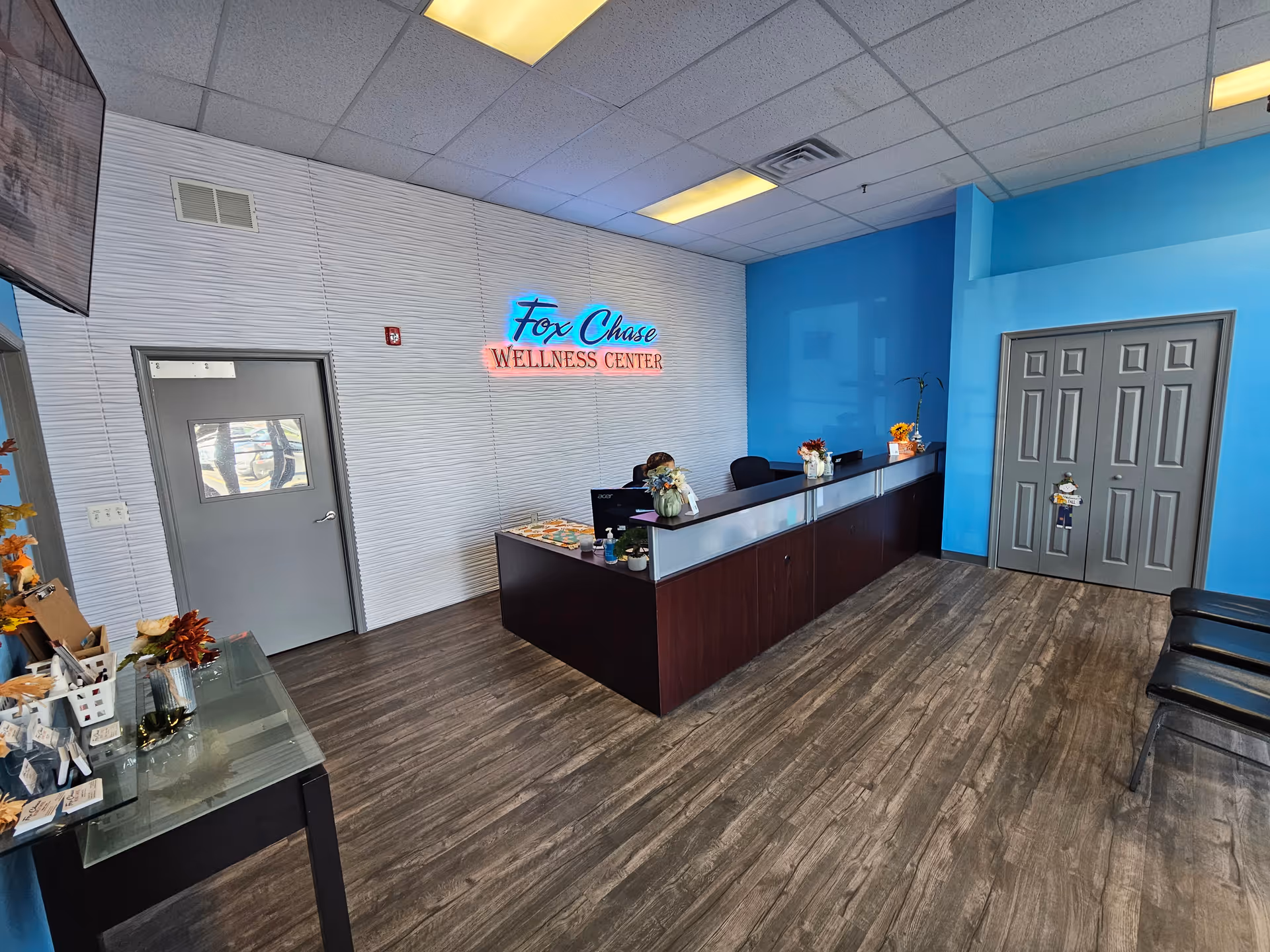 Bright lobby with reception desk and blue walls at Fox Chase Wellness Center.