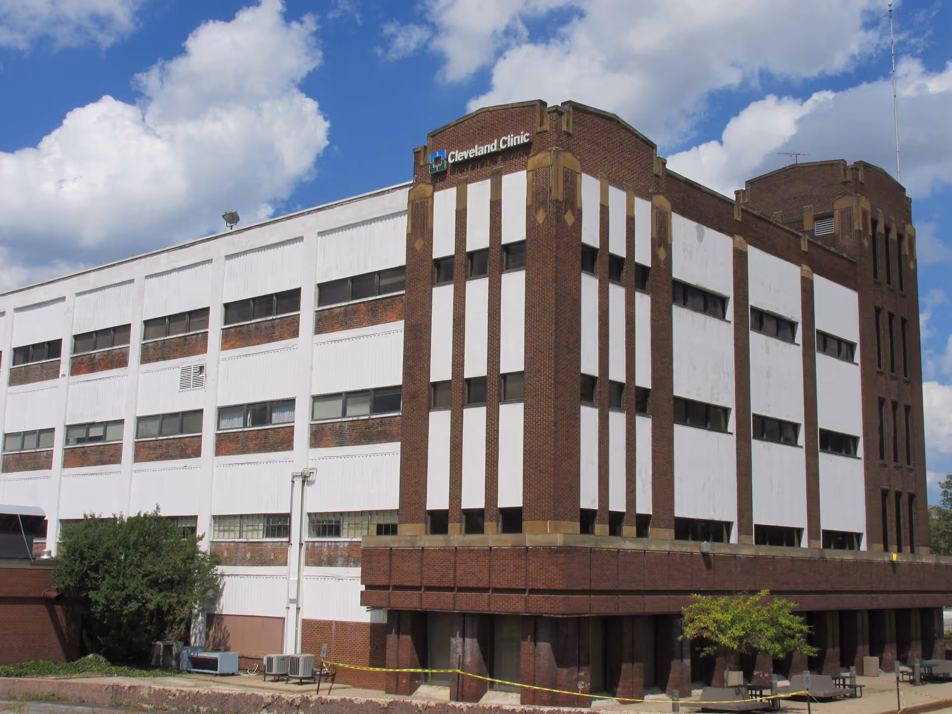 Large brick-and-white clinic building with a Cleveland Clinic sign against a blue sky.