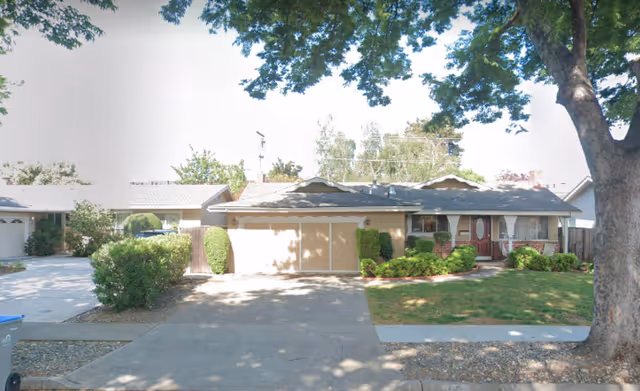 Front view of Hope's Creek Retirement Living building with a driveway and trees.