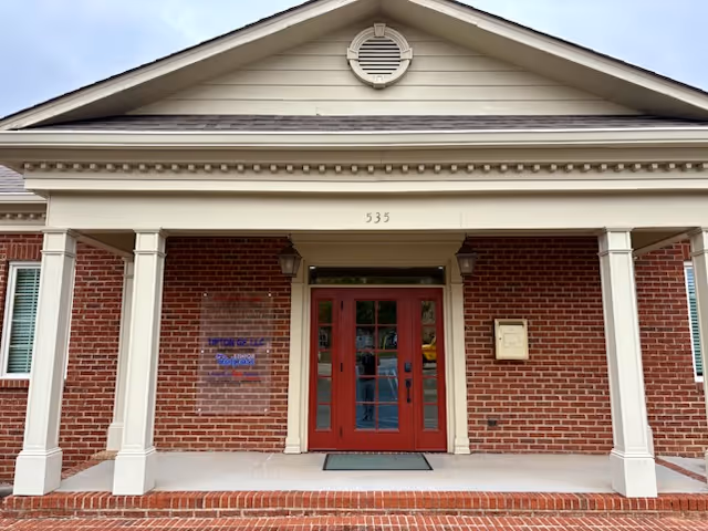 Front entrance of Senior Helpers of Maryville, a senior living facility, with red doors and columns.