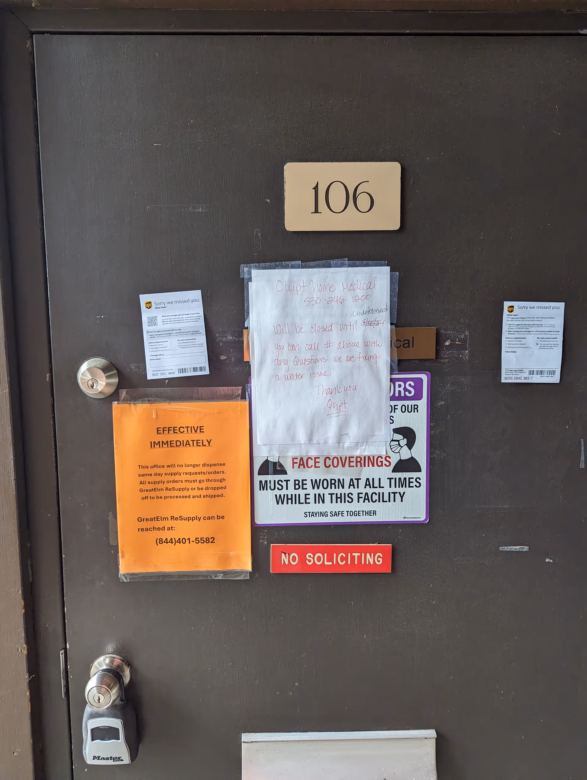Dark door marked 106 with multiple posted notices and signs.