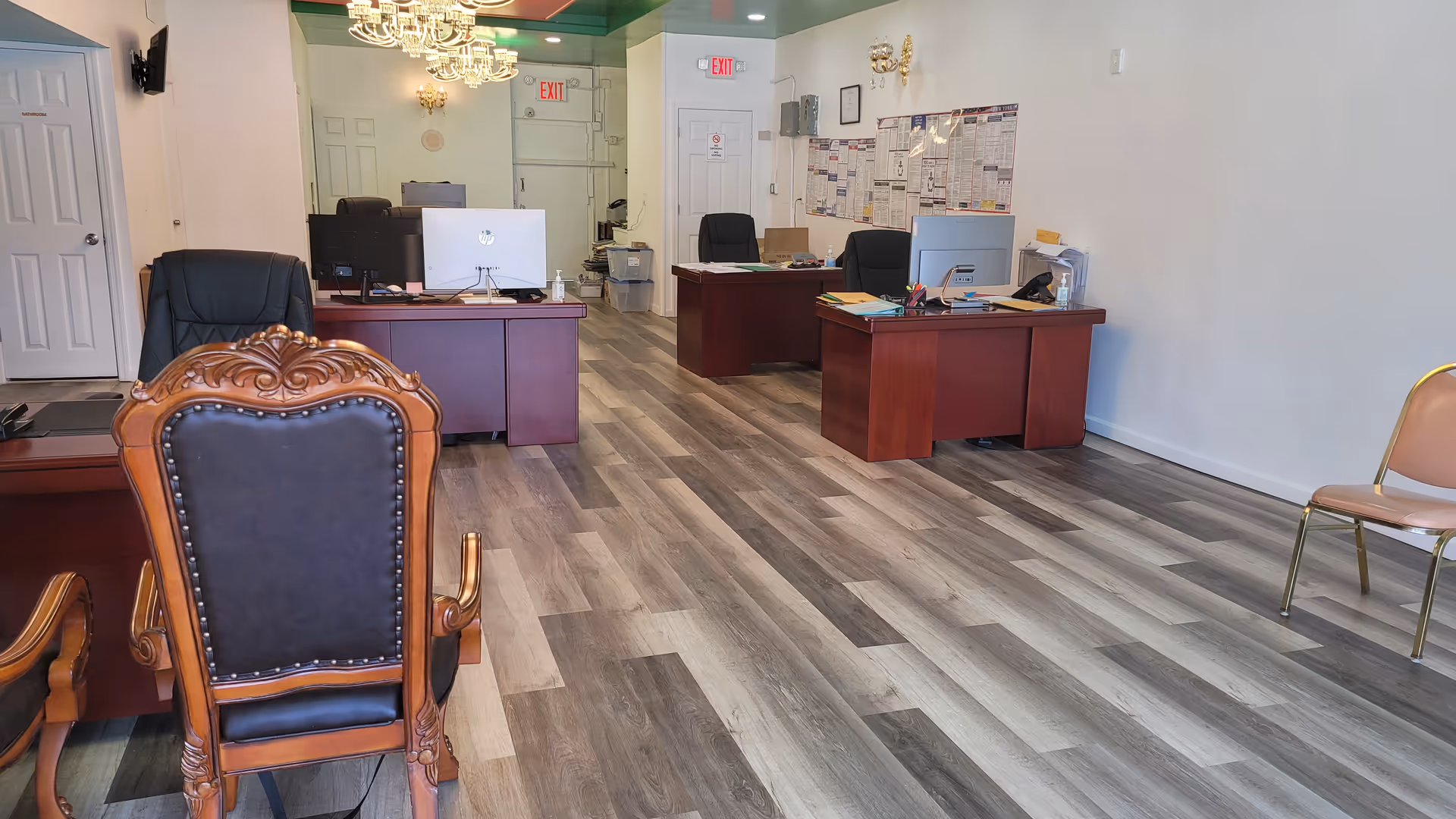 Lobby and reception area with desks, computers, and an ornate chair in foreground.