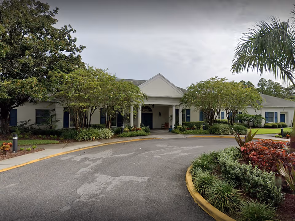Single-story facility exterior with a curved driveway, landscaping, and a portico entrance.
