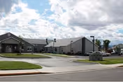 Exterior view of Assisted Living at the Colonnade with low-rise buildings, parking, and landscaping.
