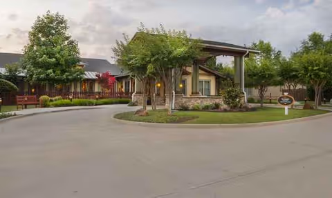Front exterior of Sunrise of Fort Worth showing entrance, trees, and a circular driveway.