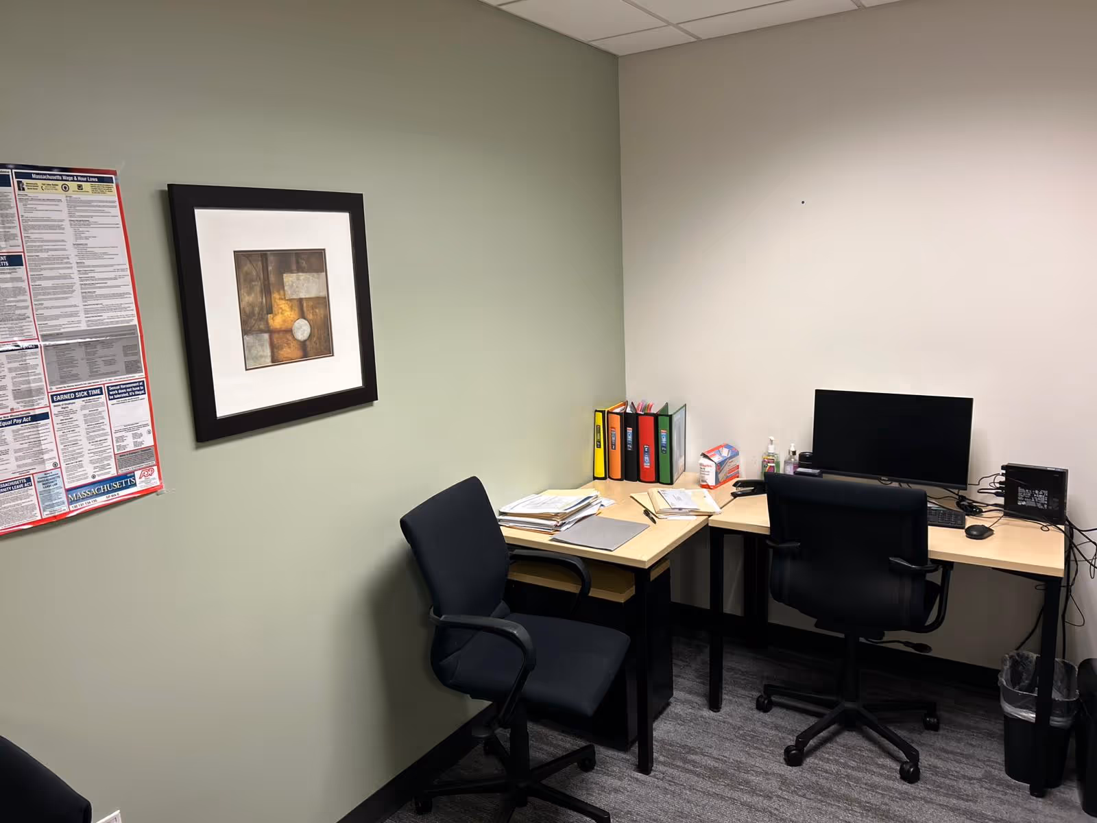 Office workspace in a senior living facility with a desk, computer, and binders.