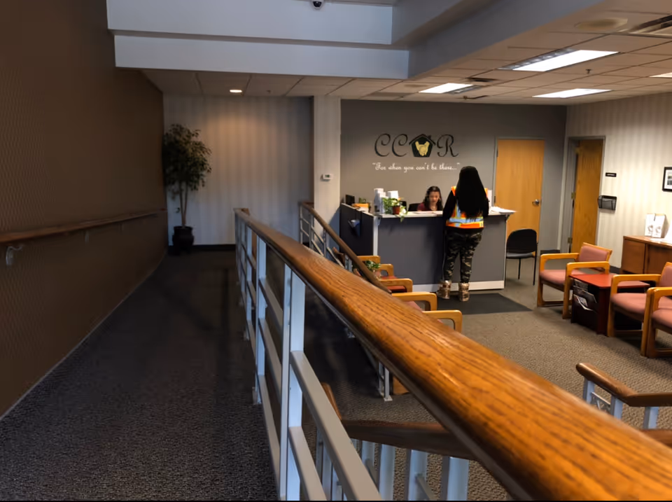 Lobby reception area featuring CCOR logo, desk, seating, and staff assisting a visitor.