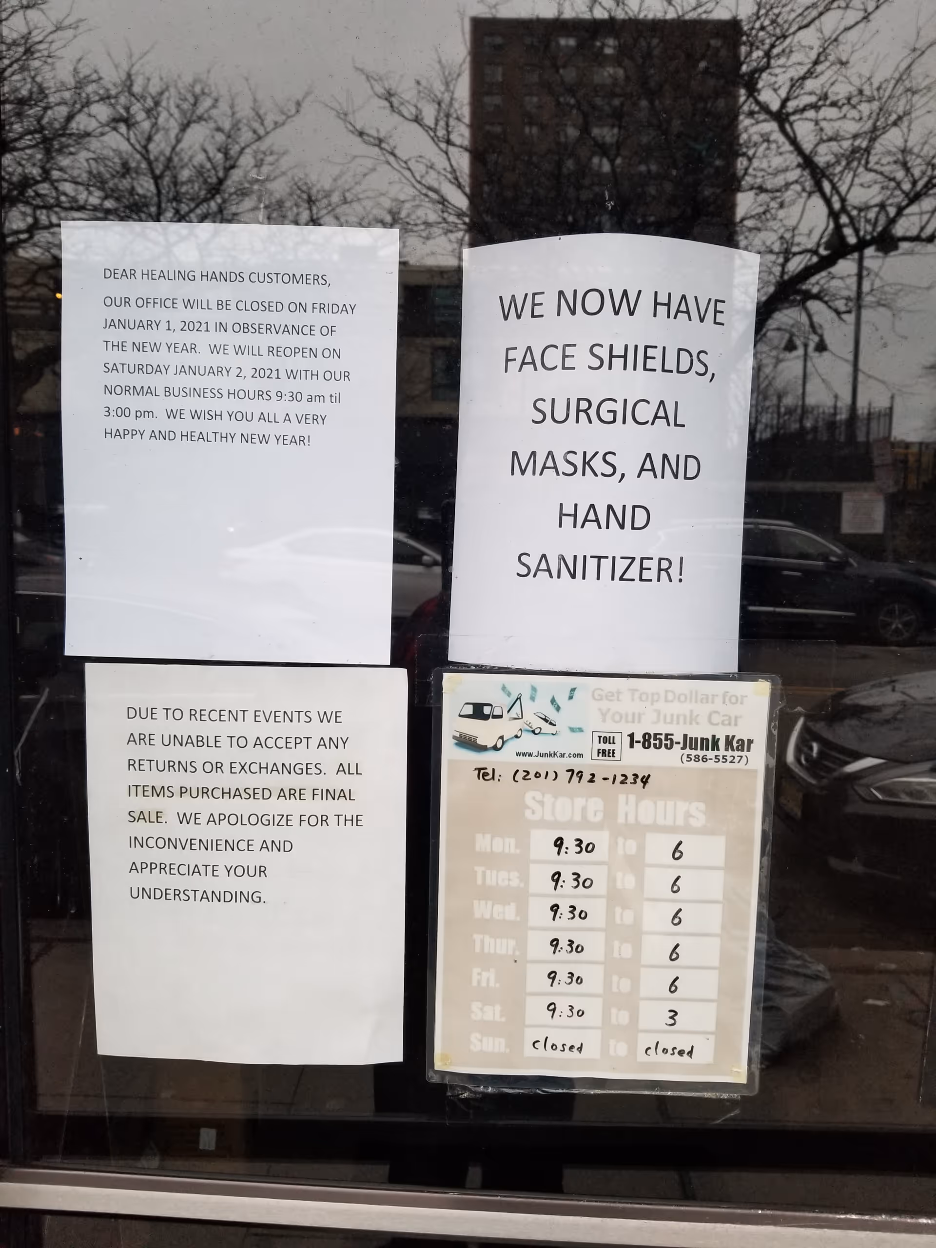 Storefront window with multiple posted notices about hours and safety policies