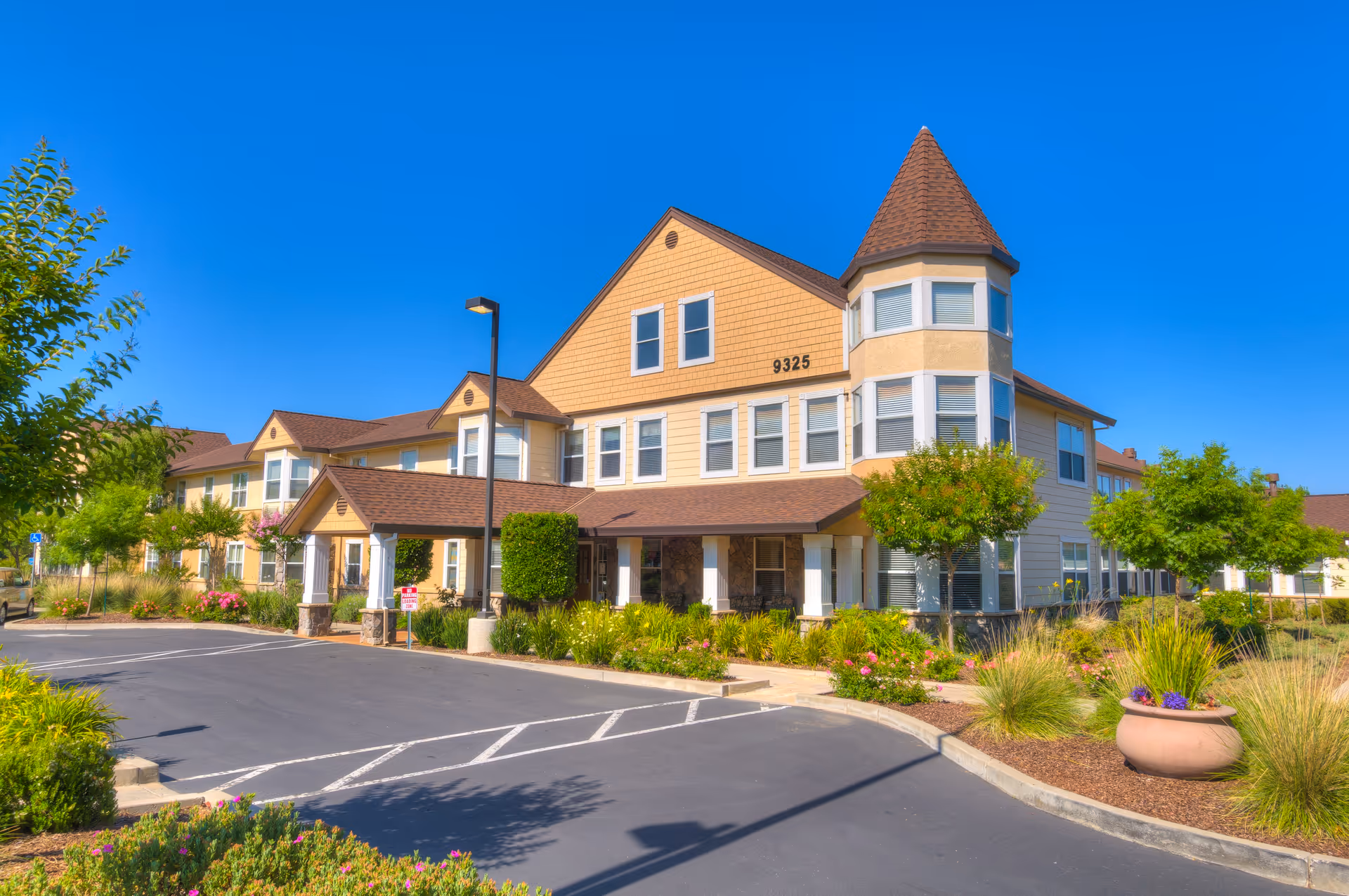Exterior view of The Meadows Senior Living building with landscaped entrance and parking.
