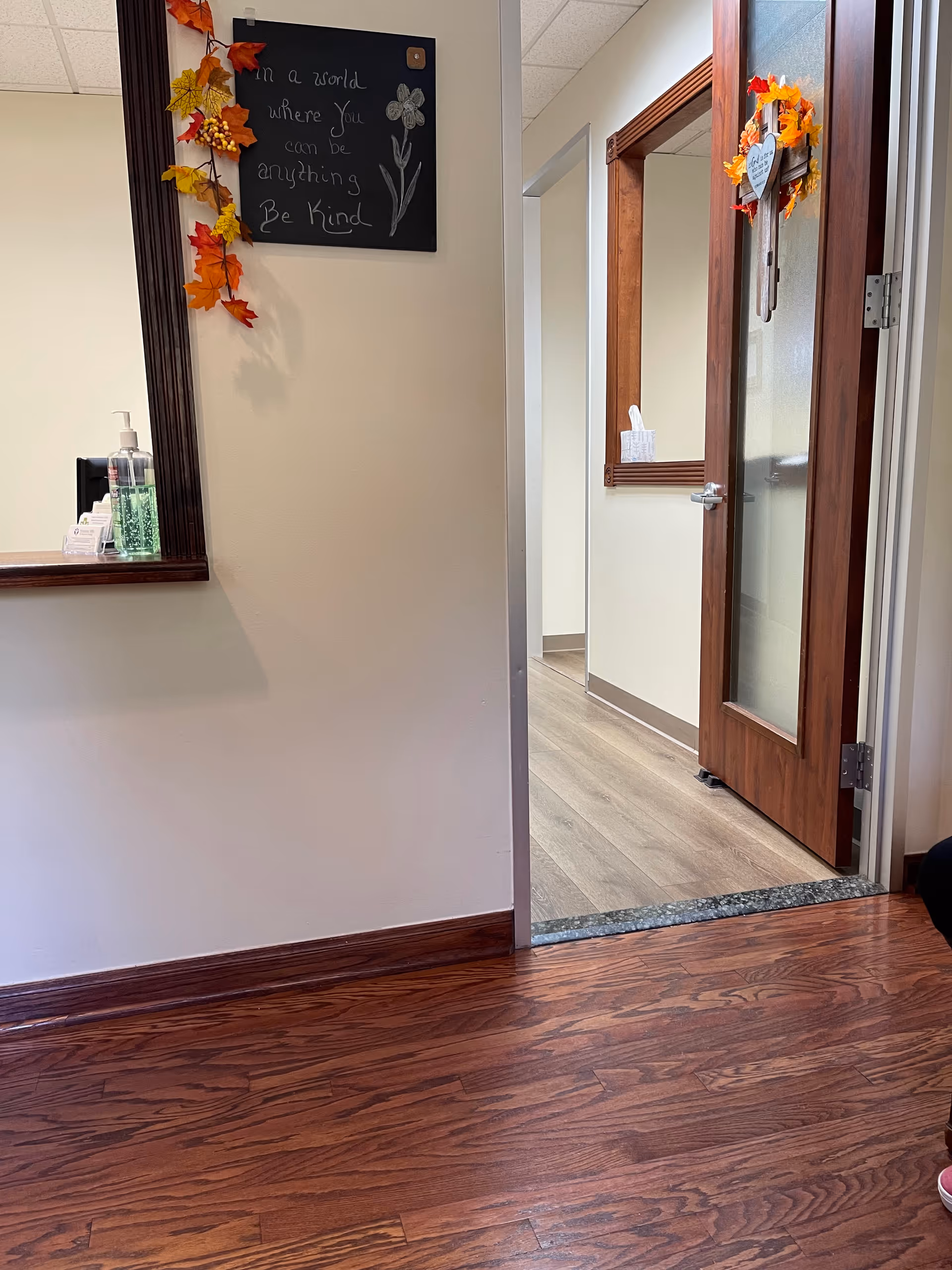 Indoor hallway at Aloma Home Care with chalkboard sign and fall decorations.
