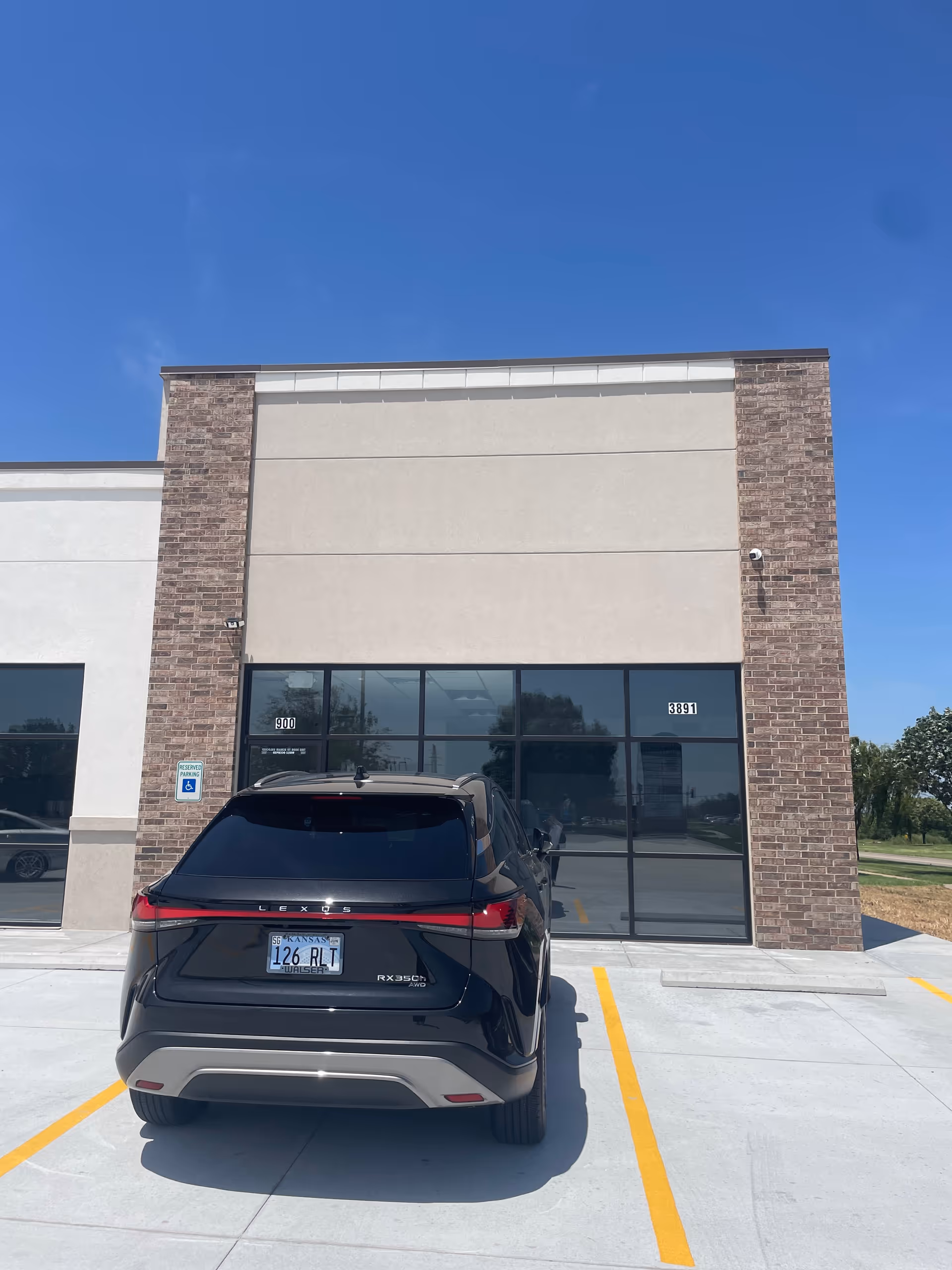 Front exterior of a facility with a parked black SUV.