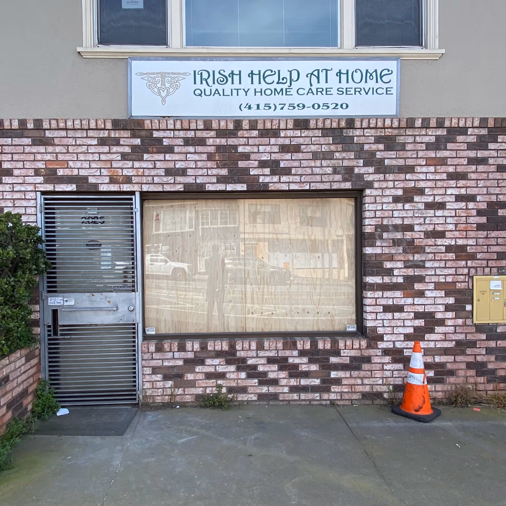 Exterior view of a brick building with Irish Help At Home sign and window.