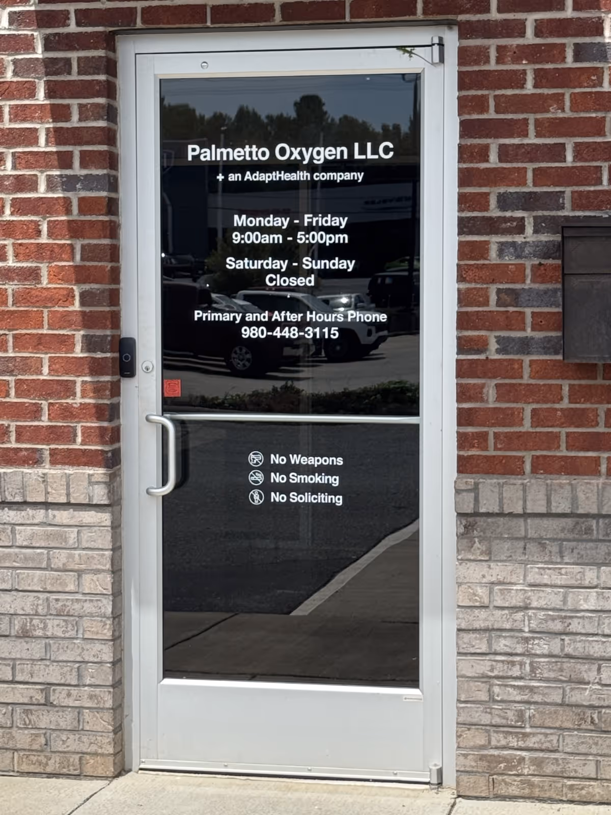 Glass door entry for Palmetto Oxygen LLC on a brick exterior.