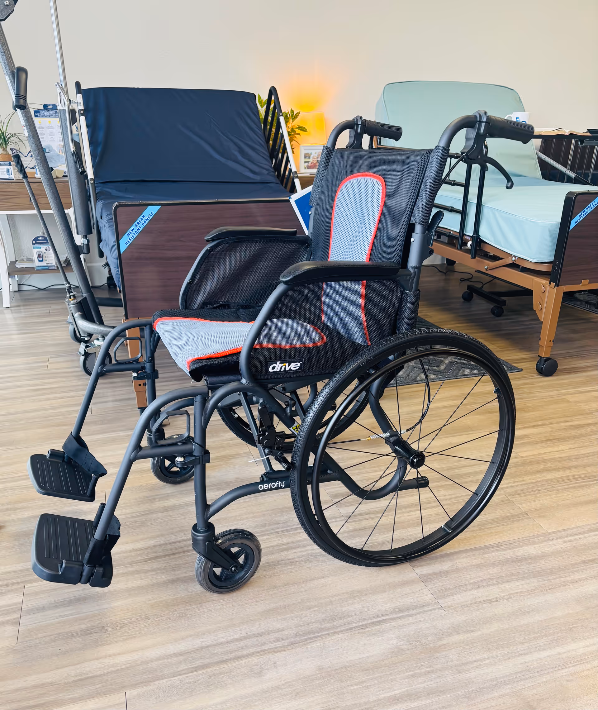 Wheelchair in a bright care facility room beside a hospital bed and medical equipment.
