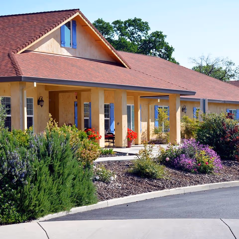 Lavender Hills Assisted Living II exterior with a covered porch and vibrant landscaped garden.