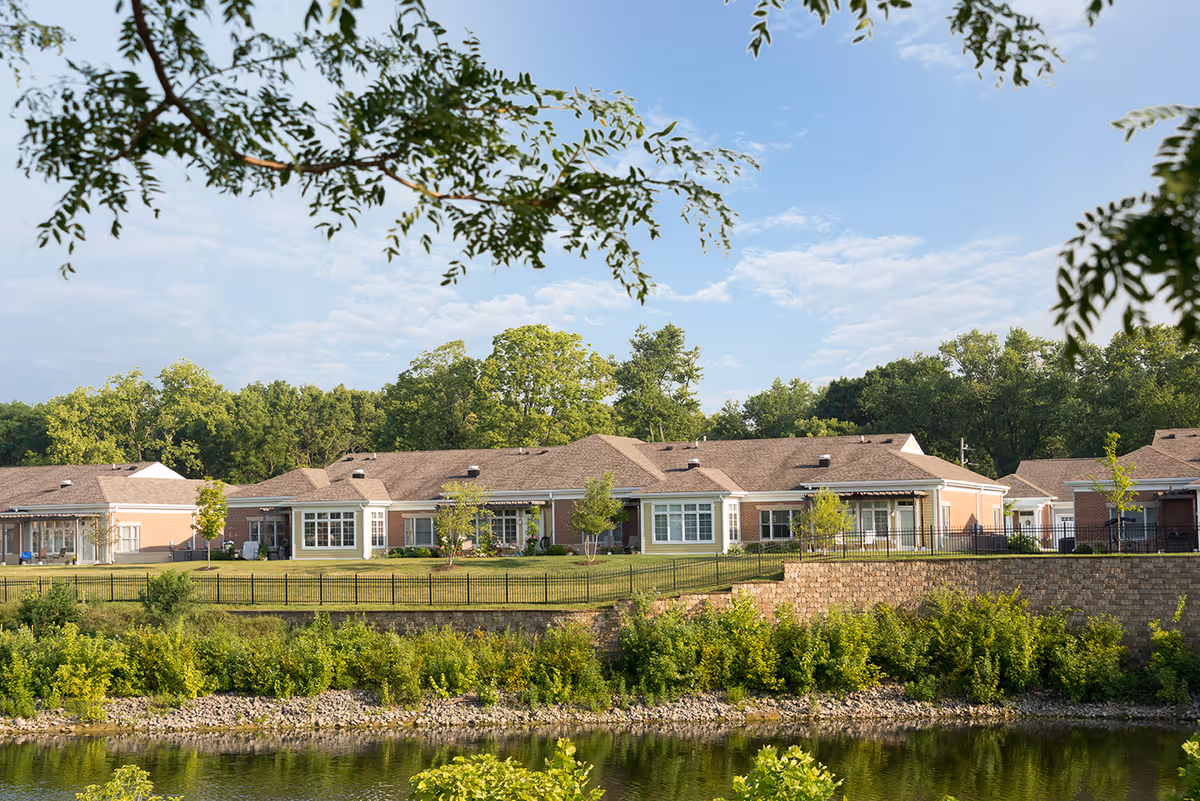 Exterior view of Traditions at Solana: single-story cottages along a lake.