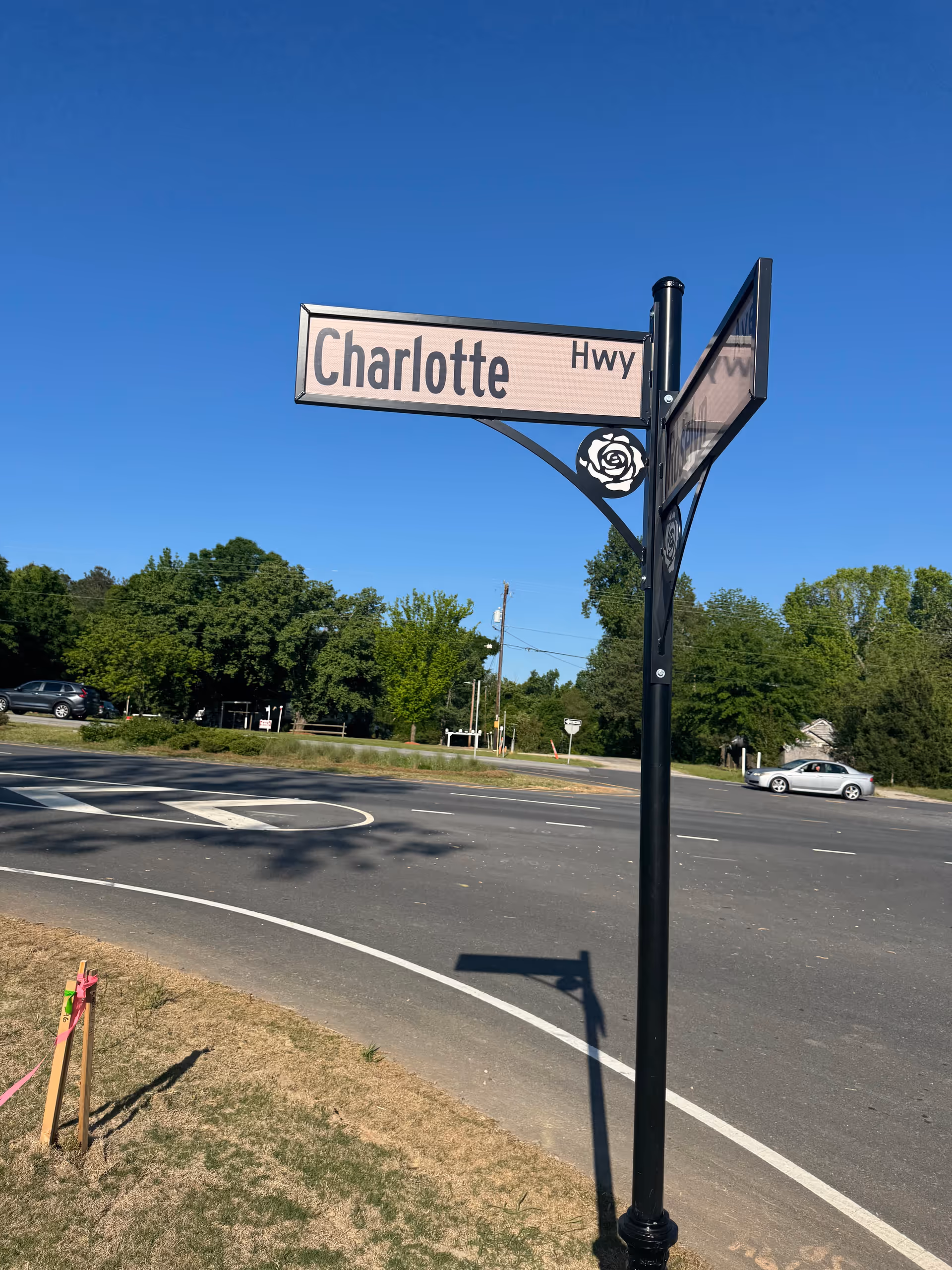 A Charlotte Hwy street sign at an intersection under a clear blue sky.
