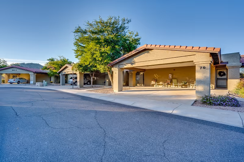 Front exterior view of a memory care facility with a covered entrance and parking.