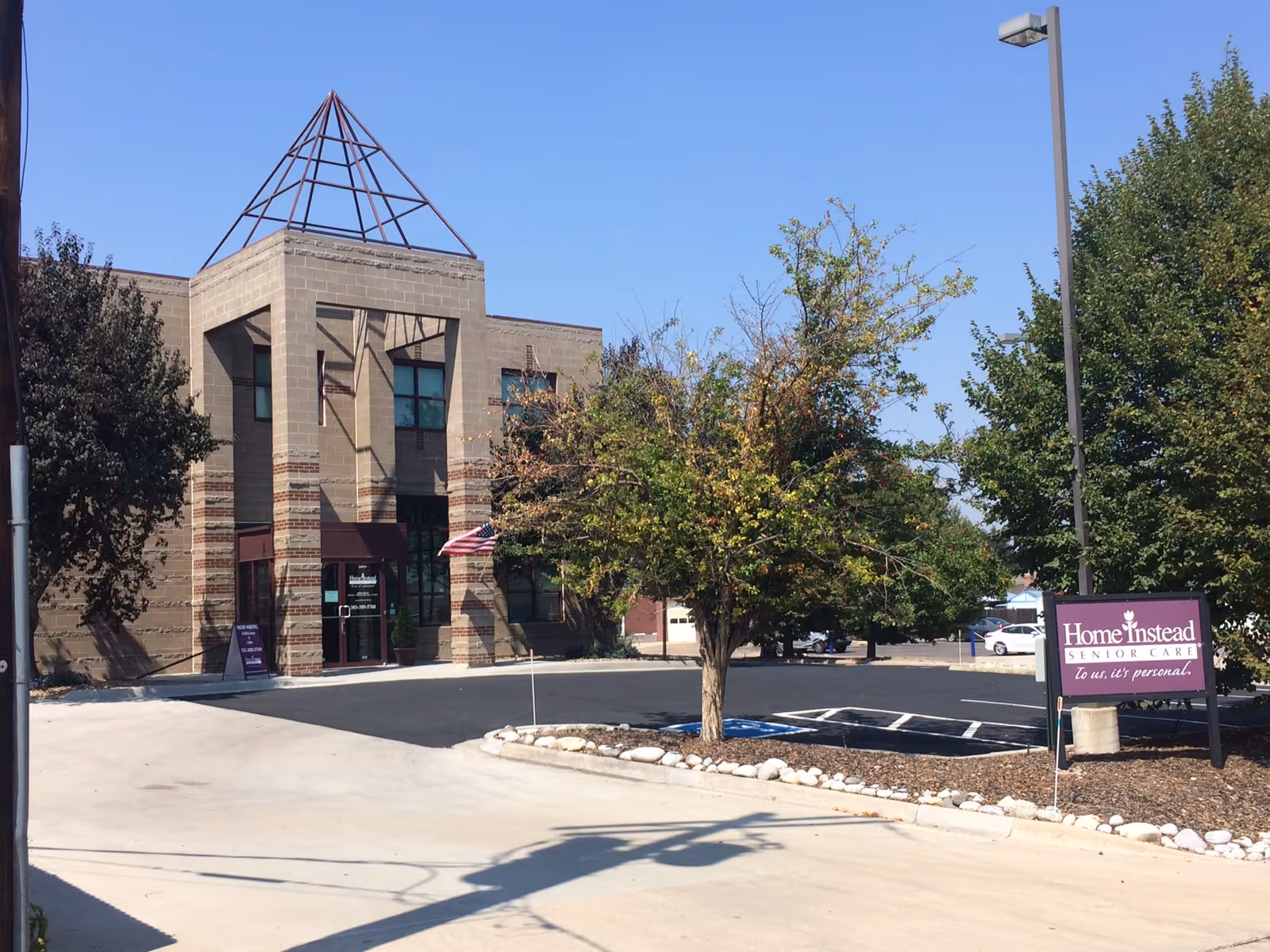 Exterior view of a Home Instead Senior Care building with a parking lot.