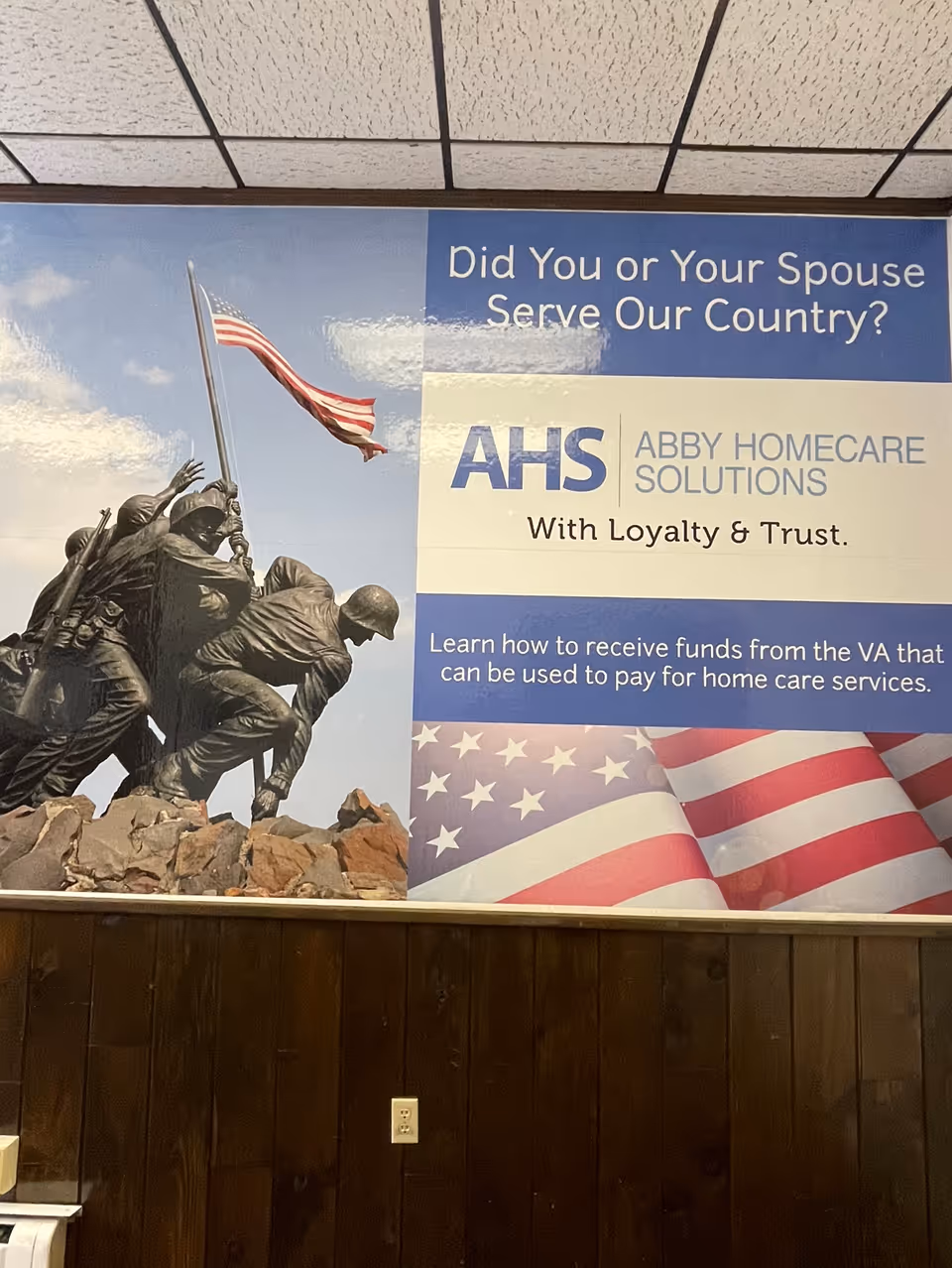 Interior wall mural at Abby Homecare Solutions showing veterans statue and flag.