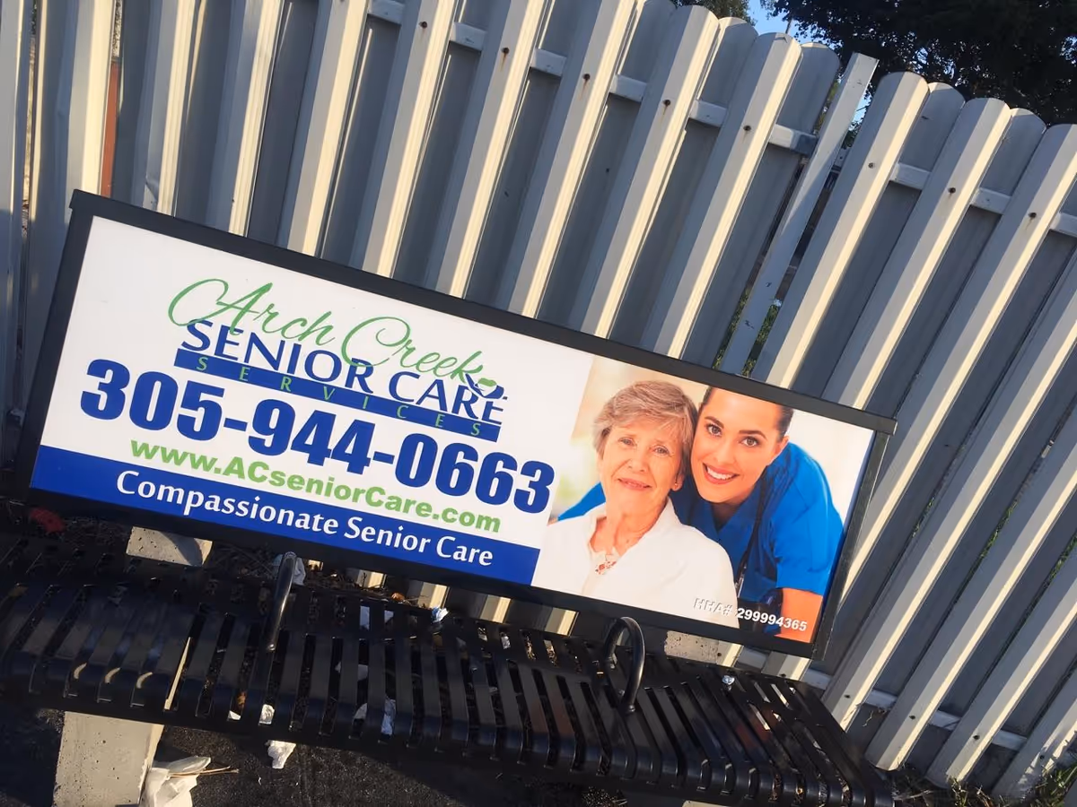 Outdoor signboard for Arch Creek Senior Care with phone number beside a metal fence