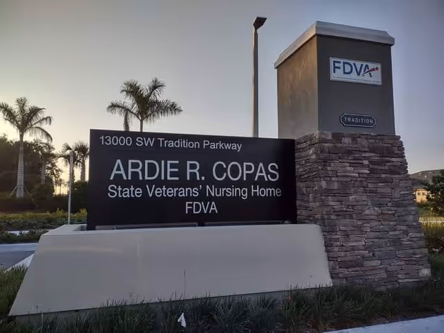 Exterior entrance sign for Ardie R. Copas State Veterans' Nursing Home with palm trees