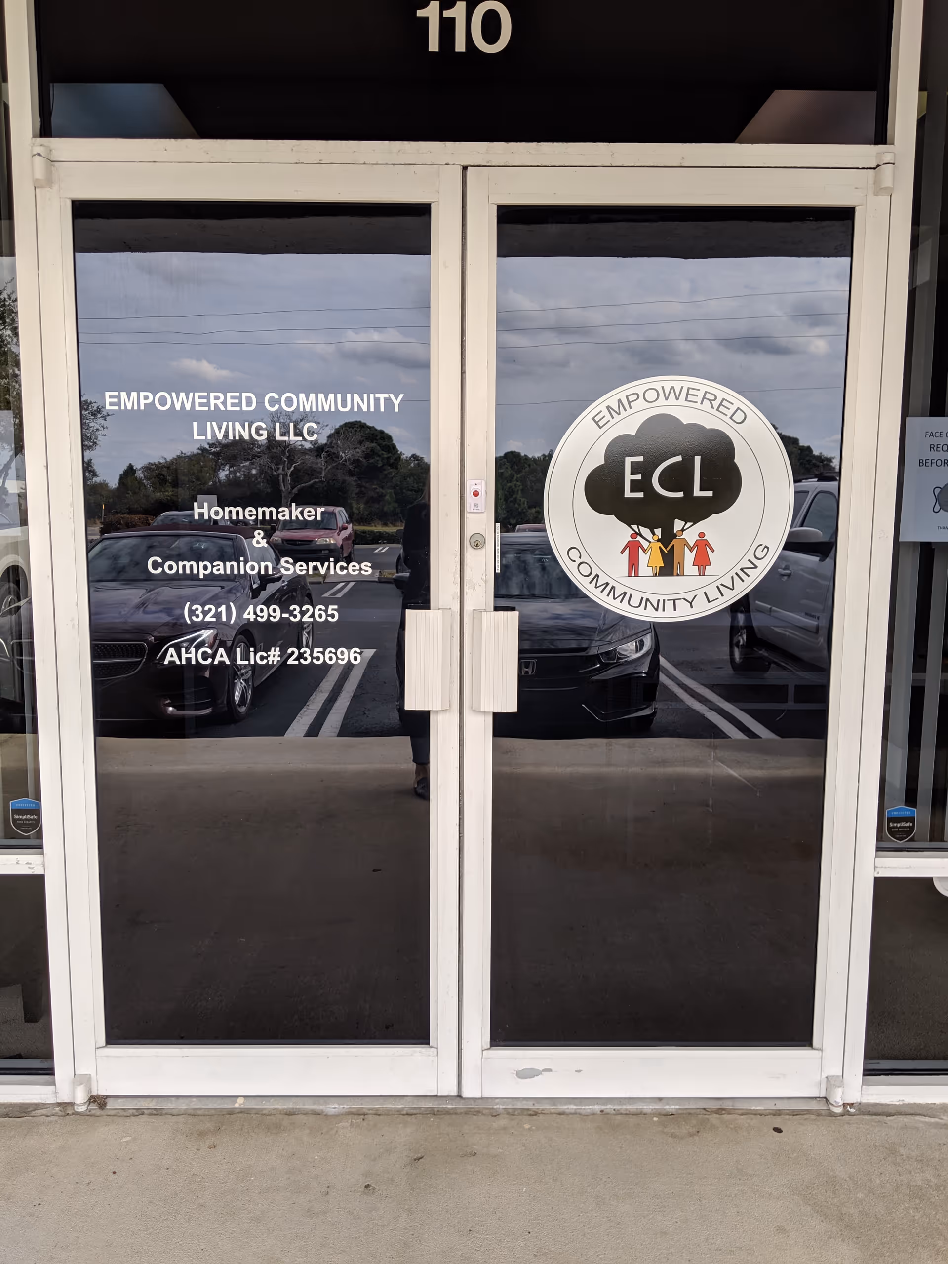 Glass doors of Empowered Community Living LLC entrance with logo and service details
