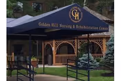 Exterior view of Golden Hill Nursing and Rehabilitation Center entrance with a blue canopy.