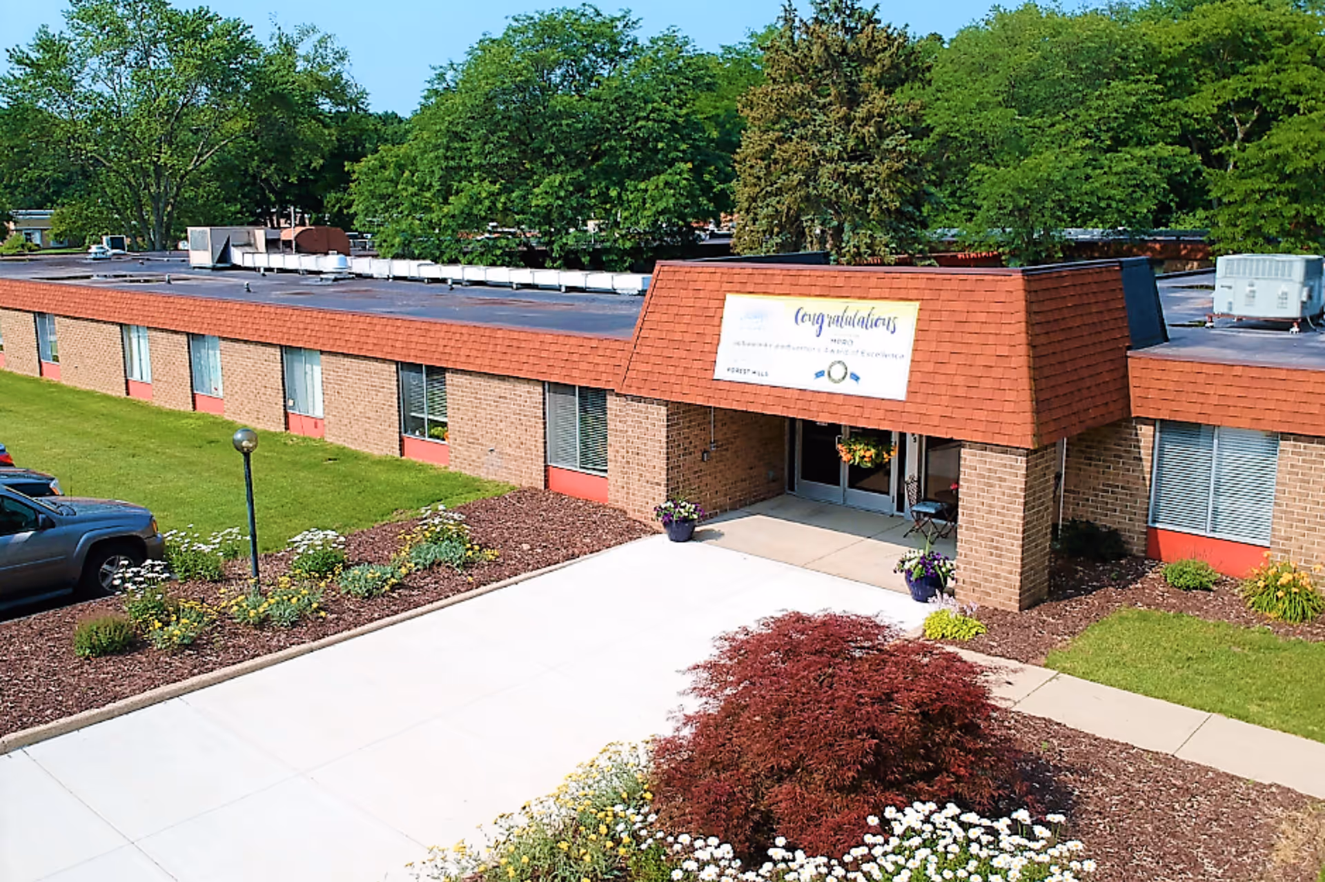 Exterior view of Metron of Forest Hills with brick building, entrance, and landscaped grounds.