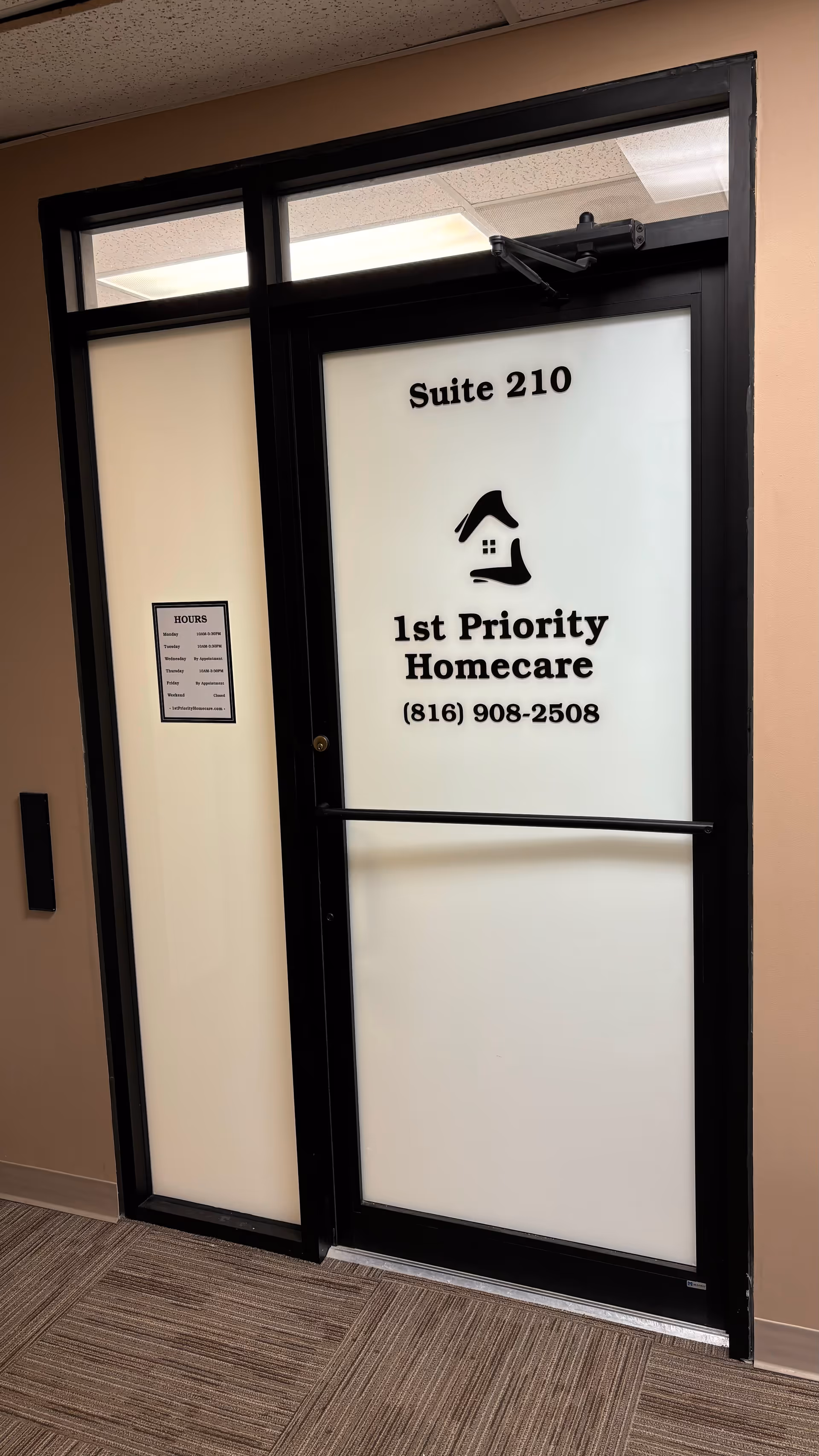 Frosted glass door labeled Suite 210 for 1st Priority Homecare in a hallway.
