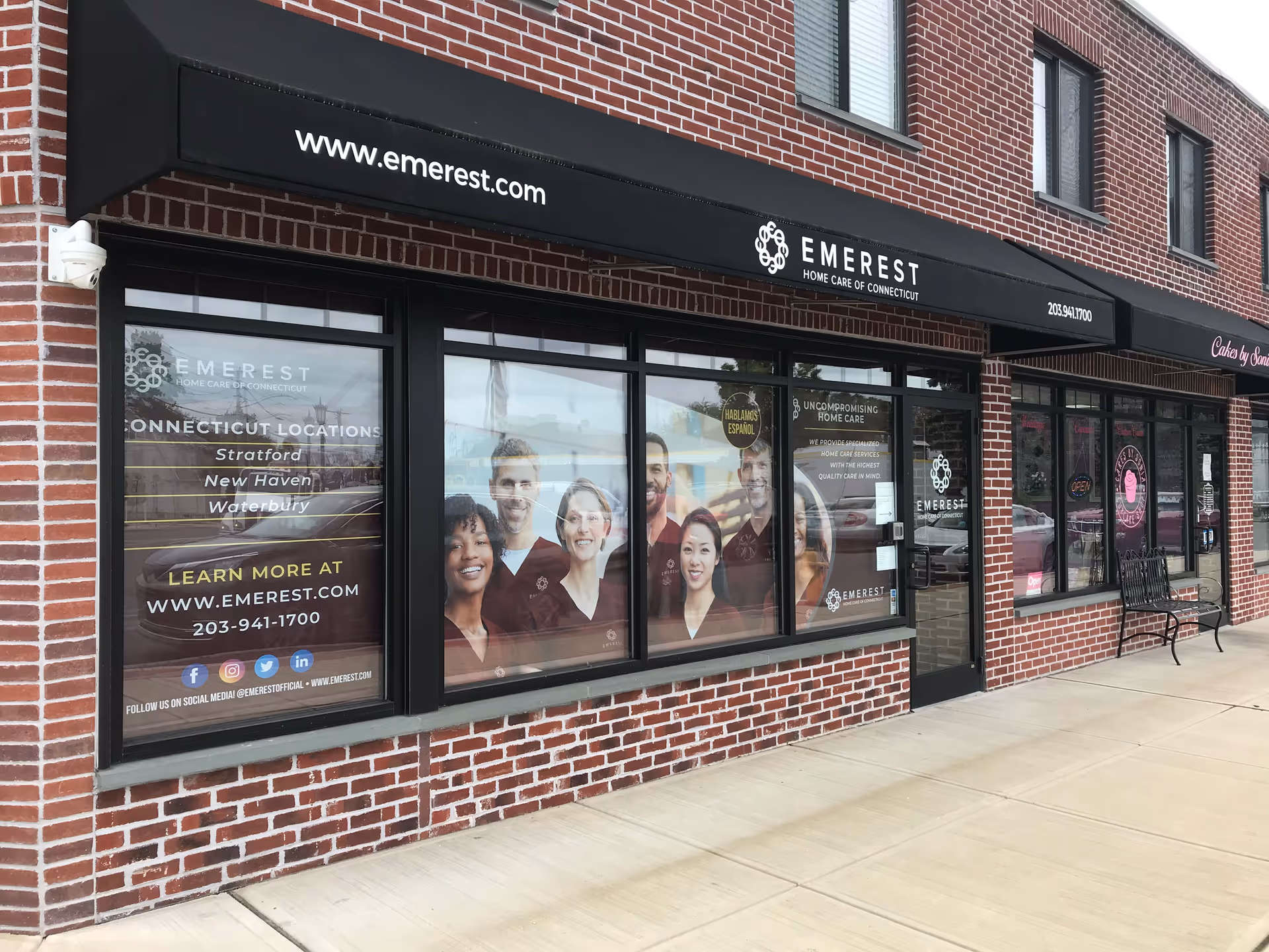 Brick storefront with large windows displaying Emerest Home Care signage.