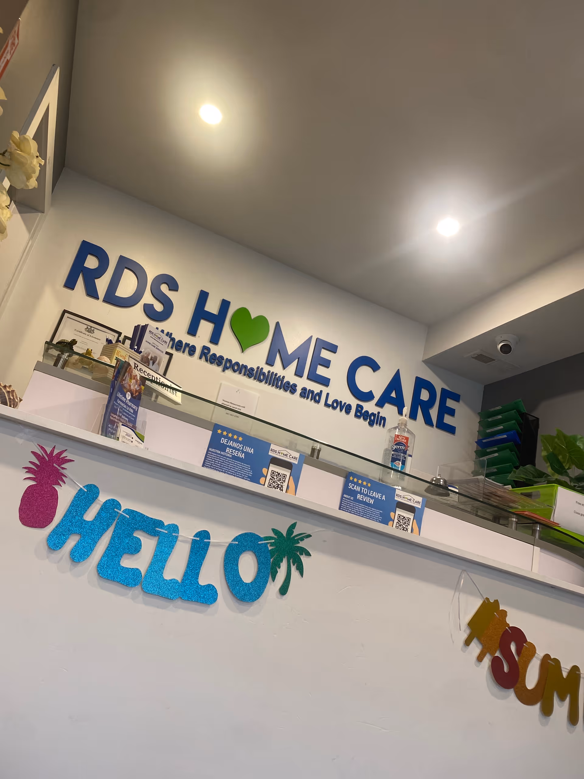 Indoor reception desk at RDS Home Care with blue sign and Hello decor.