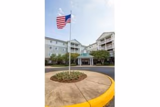 Front exterior of River Run at Prince William Commons with circular drive and flagpole.