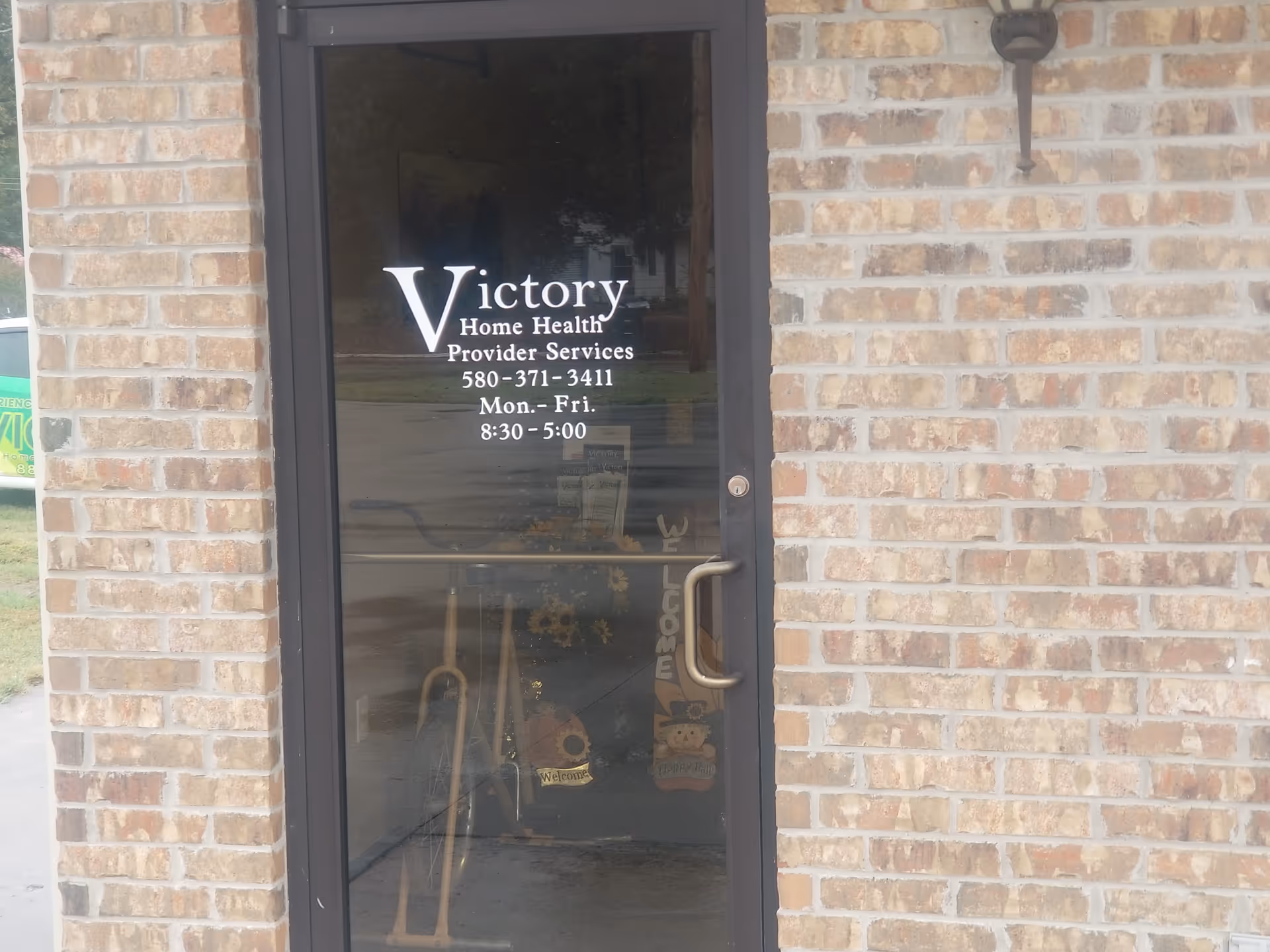 Brick exterior doorway with Victory Home Health signage on the glass door