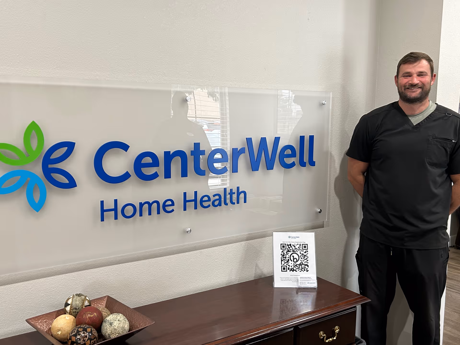 Interior hallway with CenterWell Home Health sign and a staff member in scrubs.