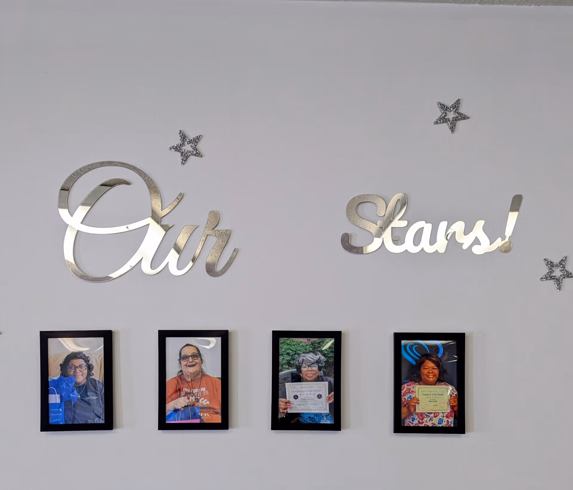 Interior wall display featuring 'Our Stars!' and four framed resident portraits.