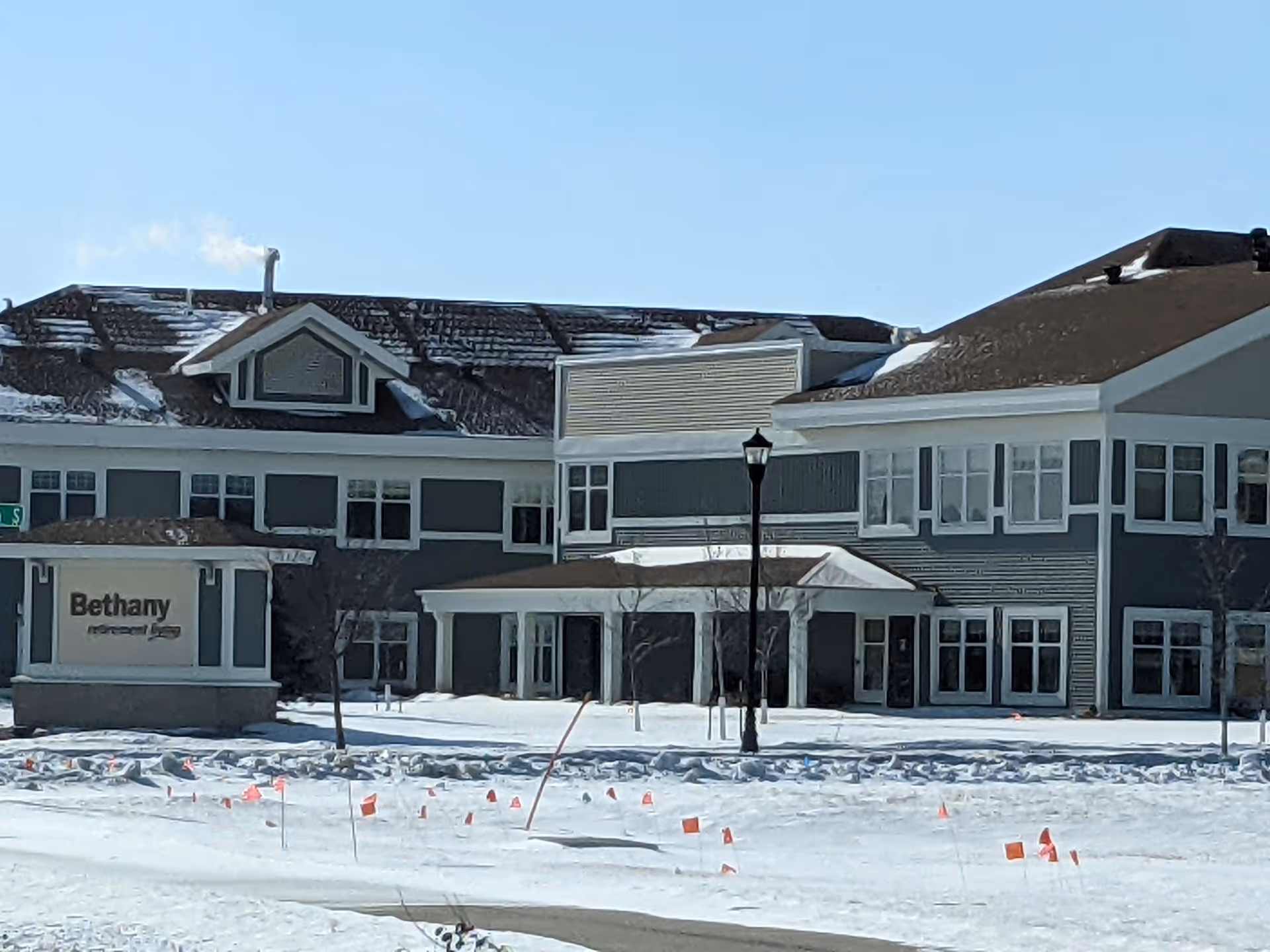 Front exterior view of Bethany on 42nd senior living with snow-covered ground.