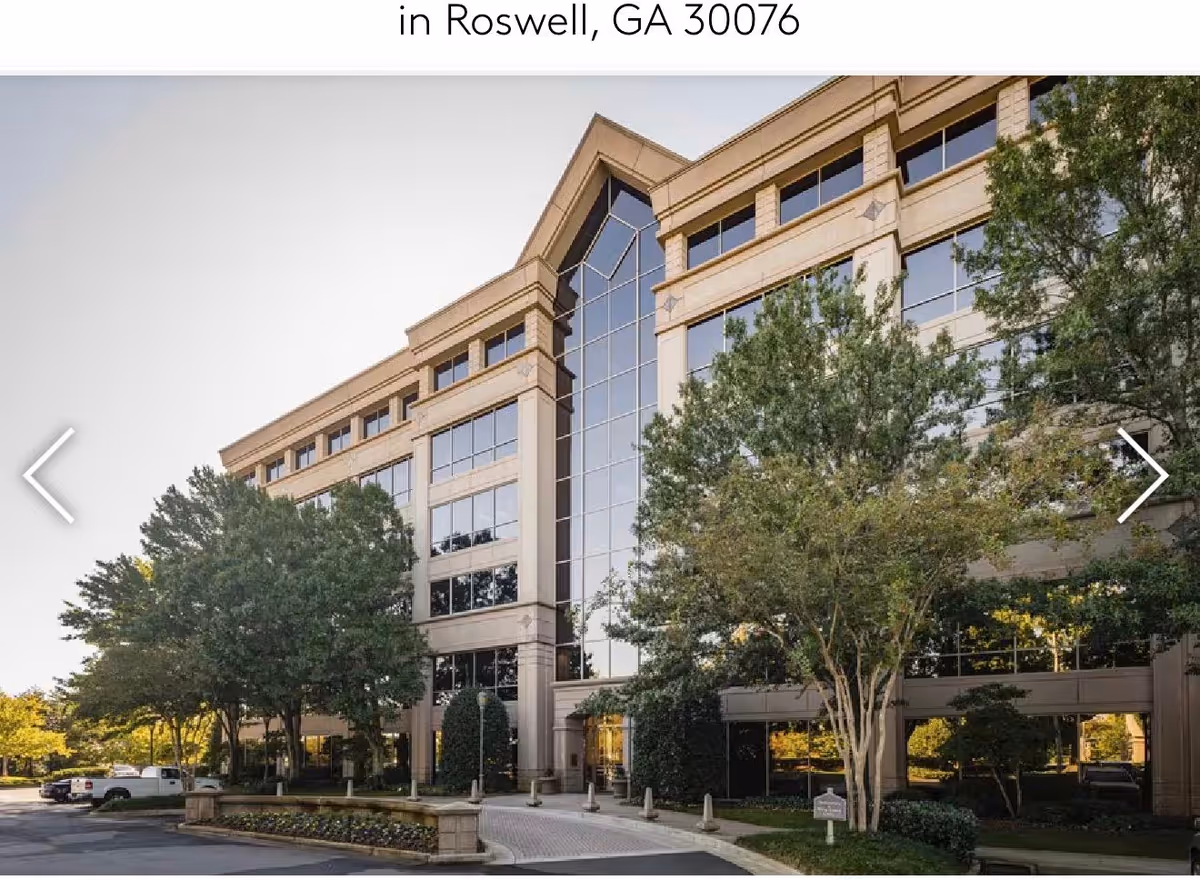 Exterior view of a modern senior living facility with large glass windows and trees.