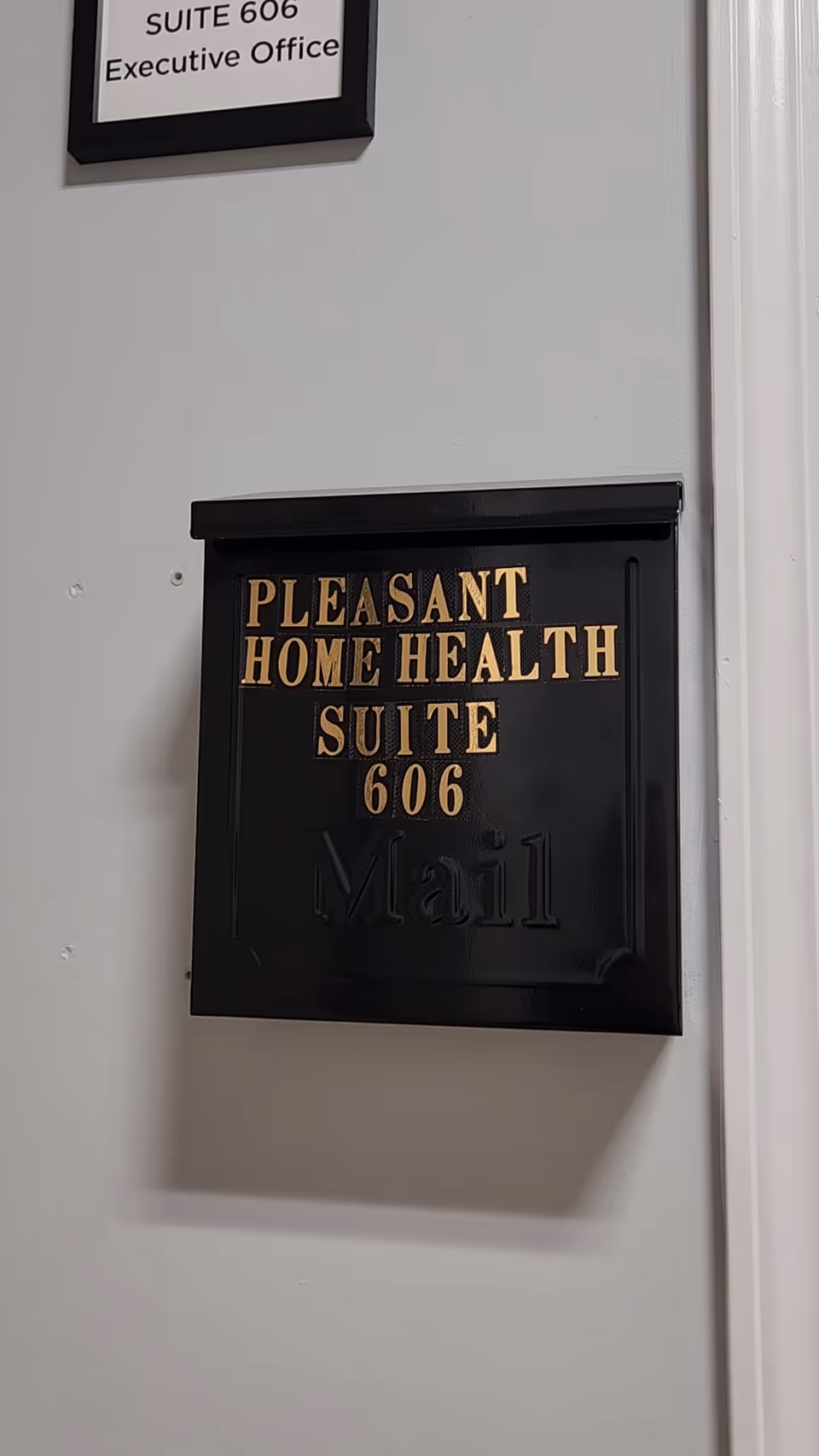 Black mailbox-style plaque on wall reads Pleasant Home Health Suite 606 Mail.