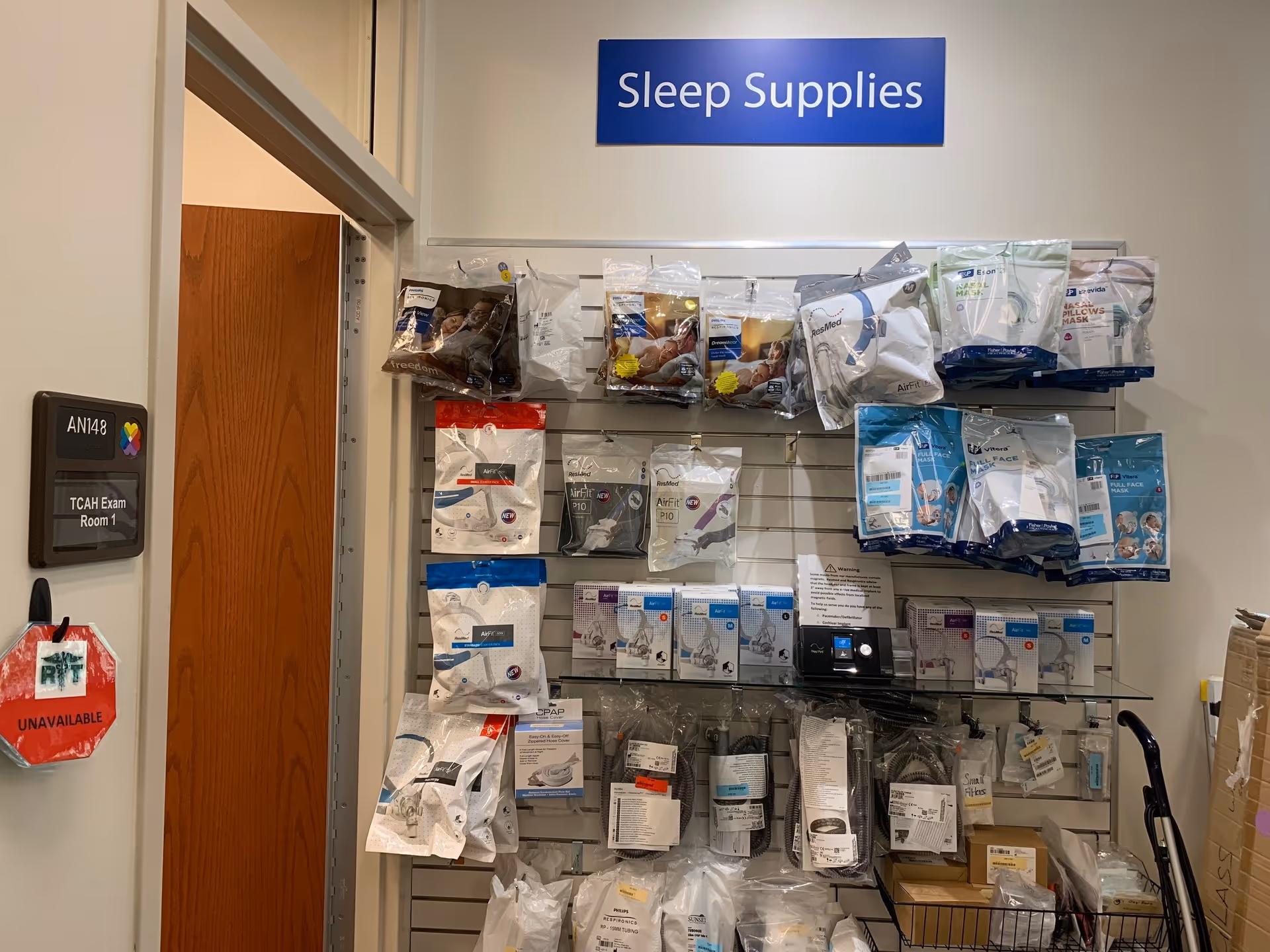 Interior supply wall with a Sleep Supplies display and assorted medical accessories on racks.