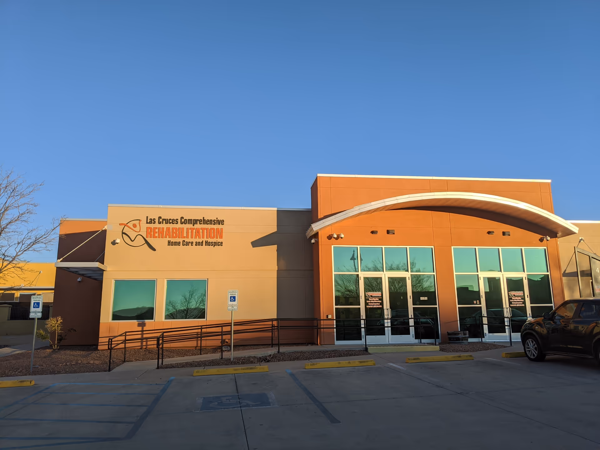 Exterior view of Las Cruces Comprehensive Rehabilitation building with orange facade and glass doors