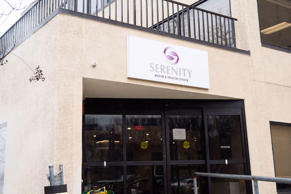 Front entrance of Serenity Rehab and Health Center with signage above glass doors.