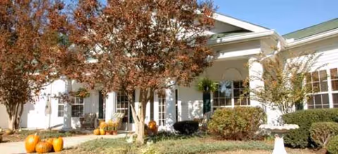 Exterior view of Brookdale Pinehurst entrance with pumpkins and autumn trees.