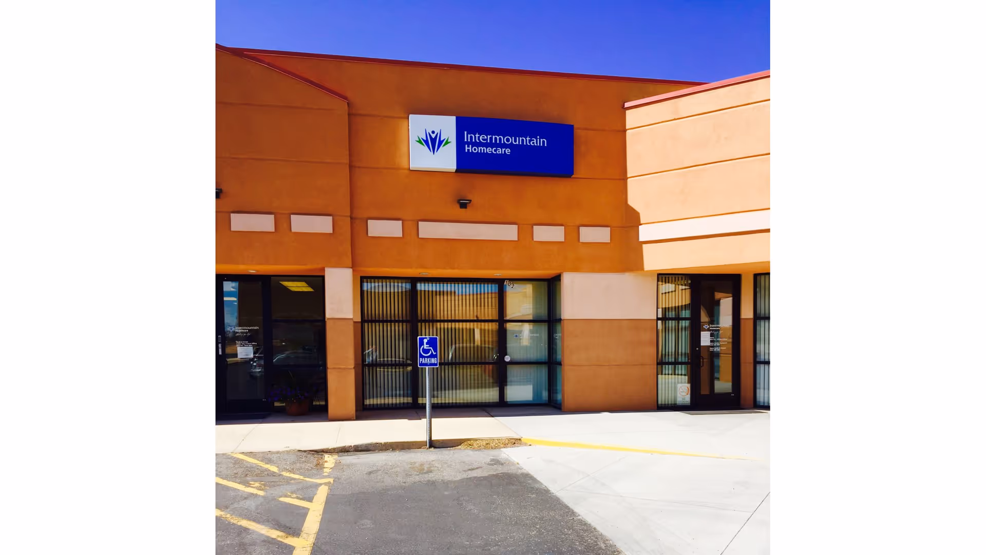 Orange-tan building exterior with Intermountain Homecare sign and glass doors