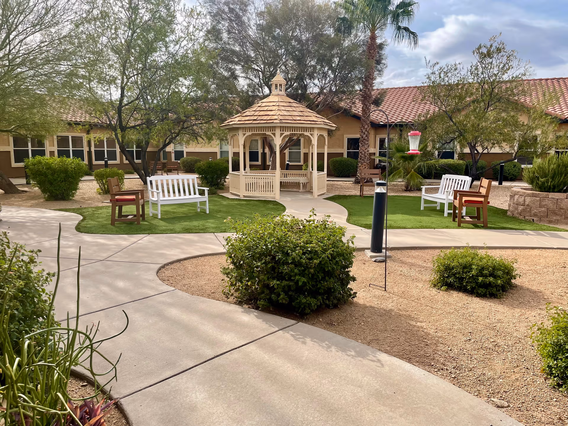 Outdoor courtyard at a senior living facility with gazebo and benches.