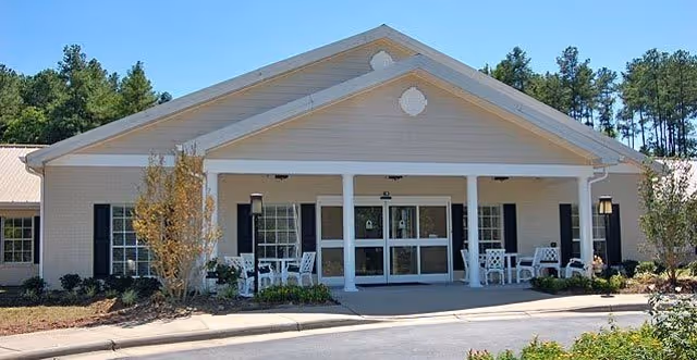 Exterior view of Seasons at Southpoint Memory Care Community with front entrance and patio seating.